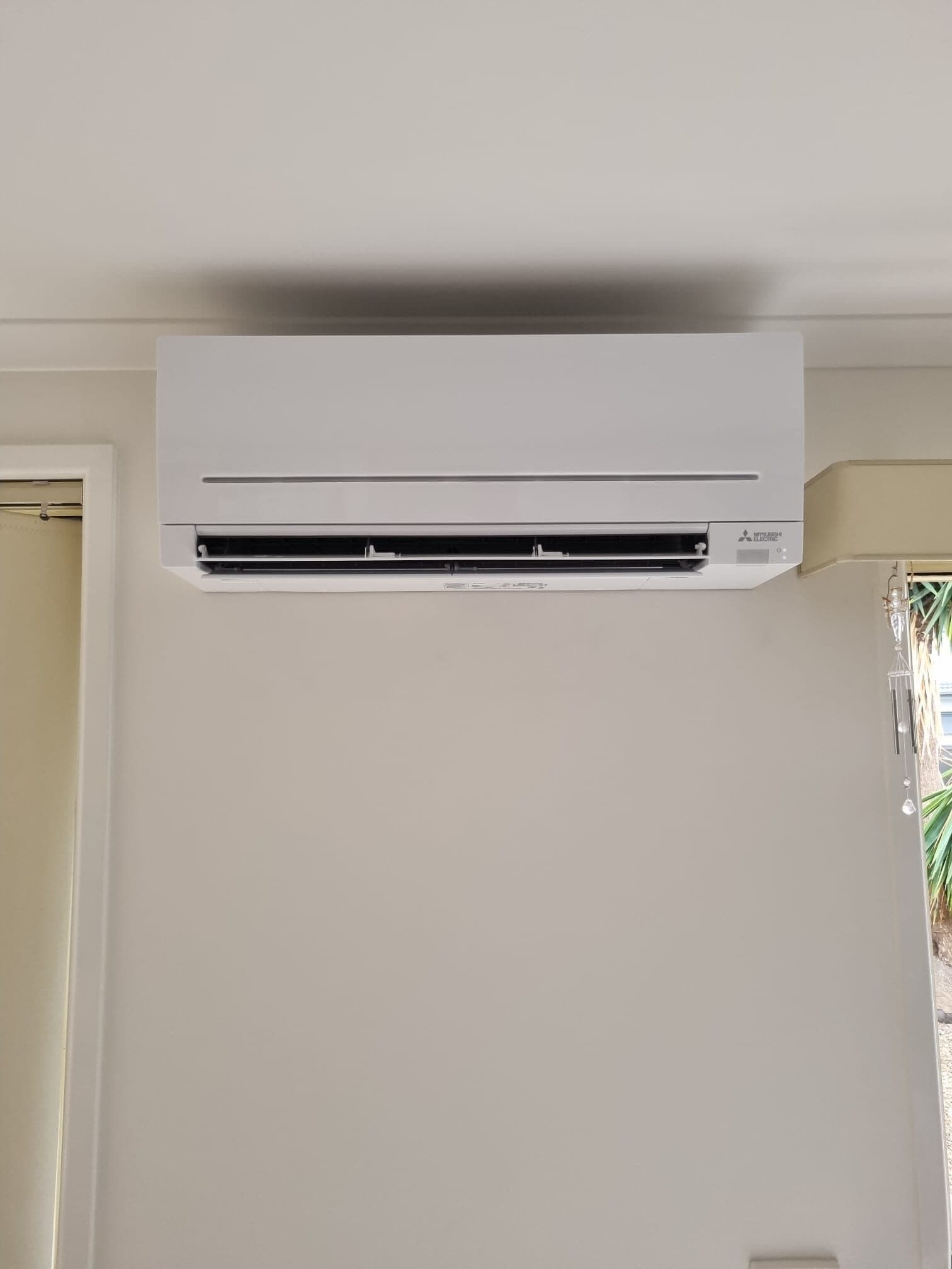 A clean wall-mounted split-system head on a neutral wall in Moonee Ponds