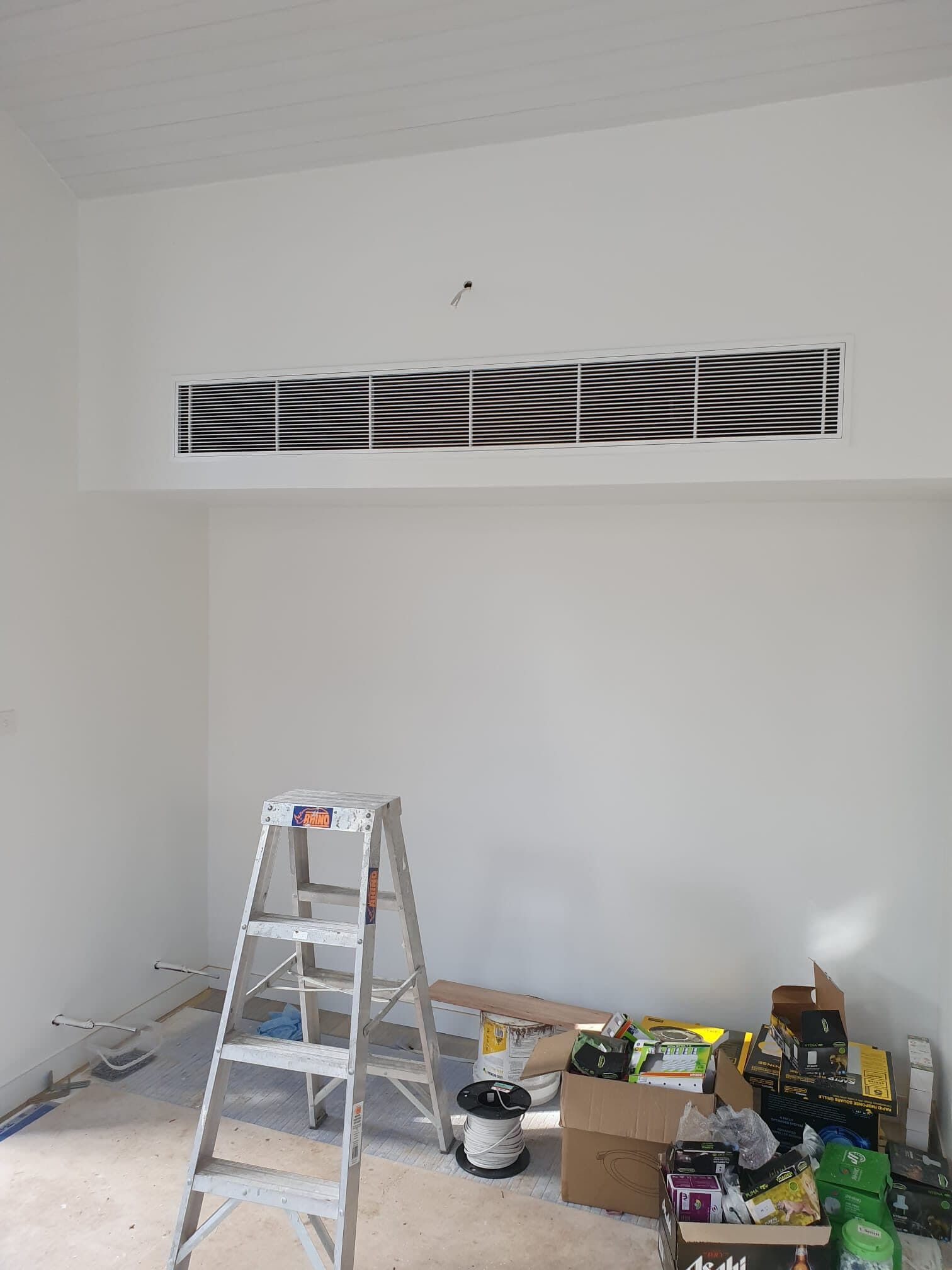 A long linear bulkhead grille set into a high wall in Newport, a clean builder fit-off