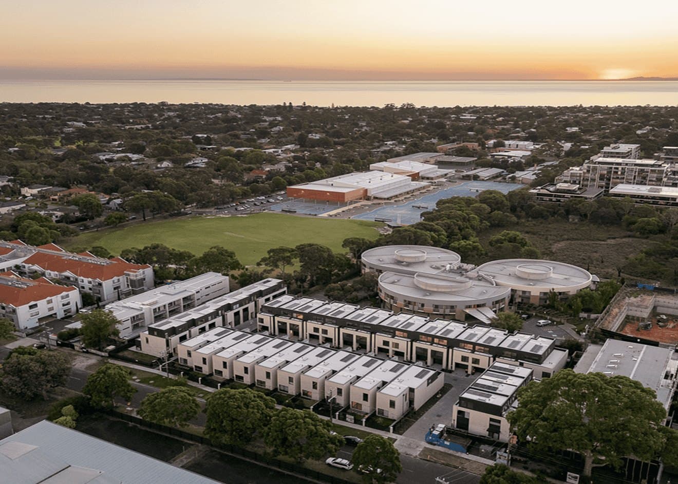 Aerial view over the Early 3191 development in Sandringham, looking across the suburb to Port Phillip Bay at sunset